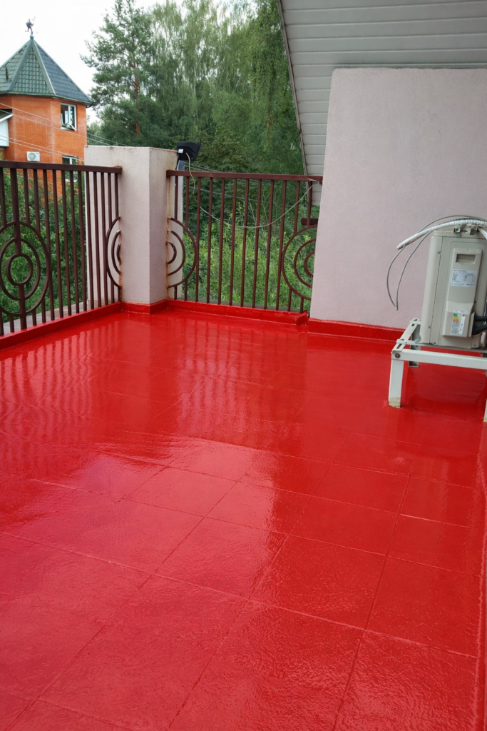 Erste Schicht Flüssigabdichtung auf Balkonfliesen aufgetragen